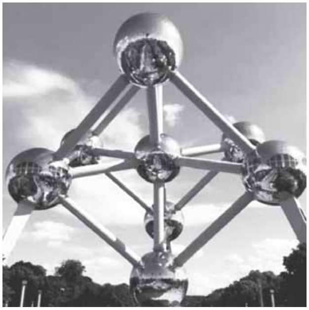 Fotografia do Atomium: esferas metálicas ligadas por tubos retos formam uma estrutura espacial. Há uma esfera no ponto mais alto, outra no centro e outra no ponto mais baixo, apoiada no solo. As demais esferas ficam distribuídas ao redor delas.
